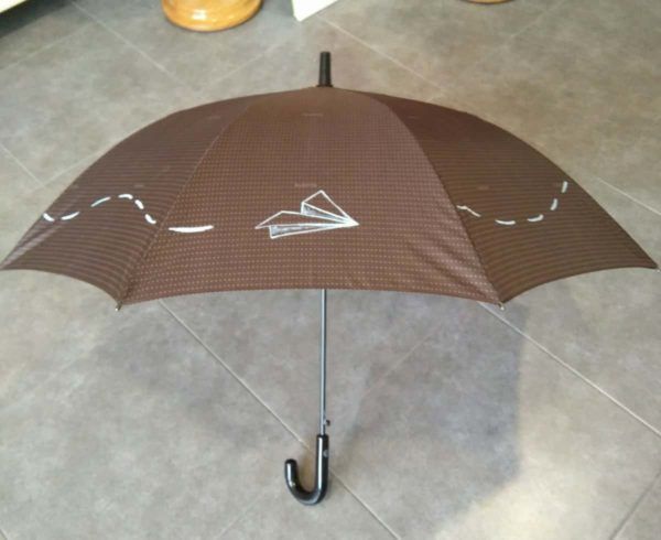 paraguas marron personalizado con el dibujo de un avión pintado a mano